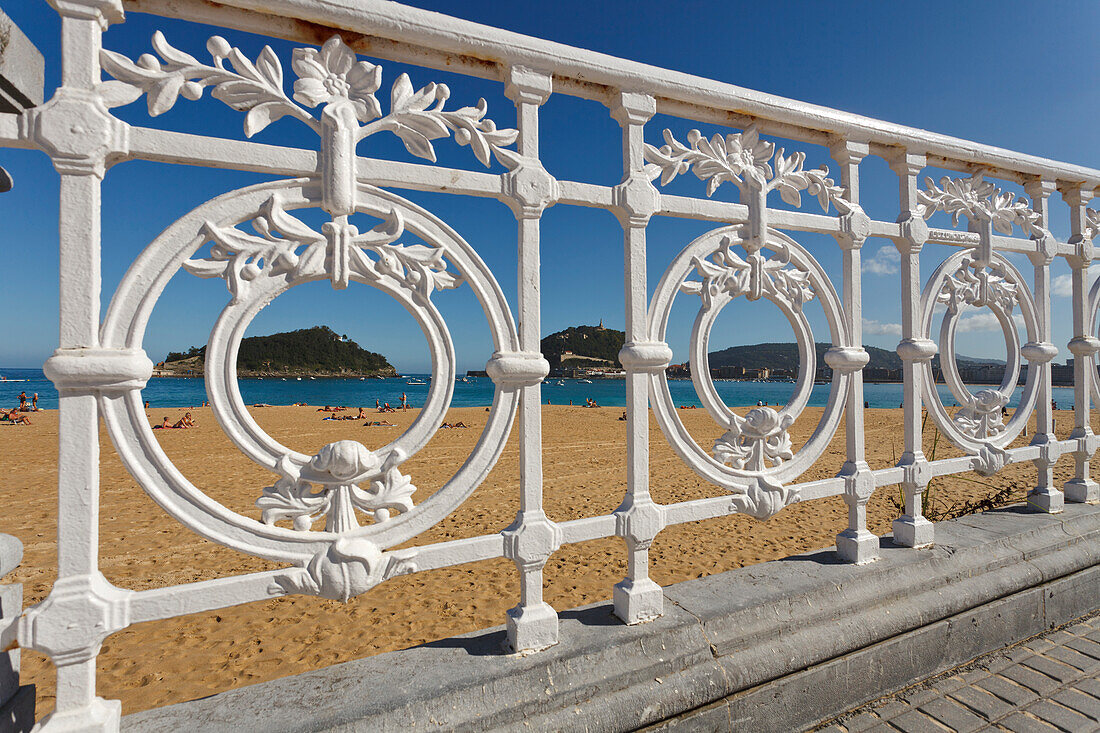 Geländer der Uferpromenade und Strand im Sonnenlicht, Paseo de la Concha, Playa Ondarreta, Isla de Santa Clara, Bahia de la Concha, San Sebastian, Donostia, Camino de la Costa, Küstenweg, Camino del Norte, Jakobsweg, Camino de Santiago, Pilgerweg, Provinz