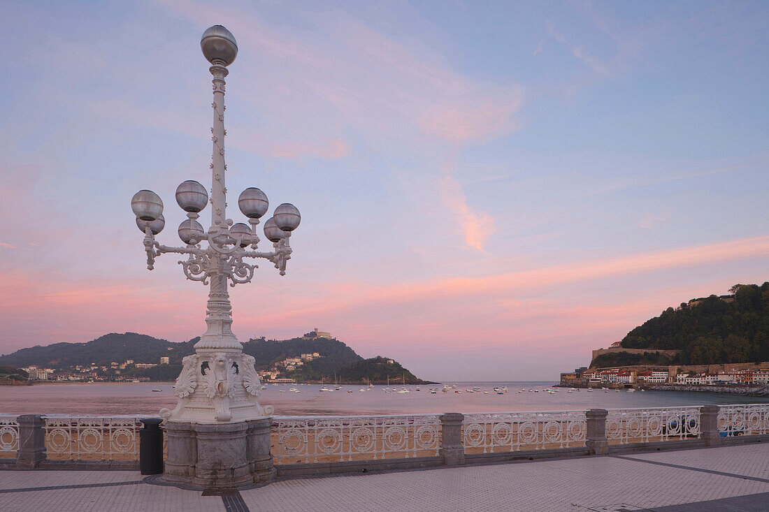 Street lamp at the seaside promenade at dusk, Playa de la Concha, Bahia de la Concha, San Sebastian, Donostia, Camino de la Costa, Camino del Norte, coastal route, Way of St. James, Camino de Santiago, pilgrims way, province of Guipuzcoa, Baskenland, Eusk