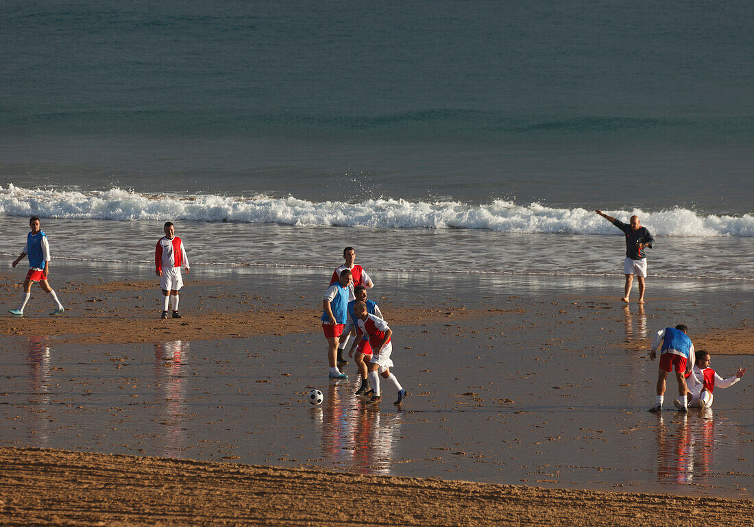 Football, training in the tidal zone, Playa El Sardinero, beach, sea, Atlantikc Ocean, Santander, Camino de la Costa, Coastal route, Camino del Norte, Way of Saint James, Camino de Santiago, pilgrims way, province of Cantabria, Cantabria, Northern Spain, 