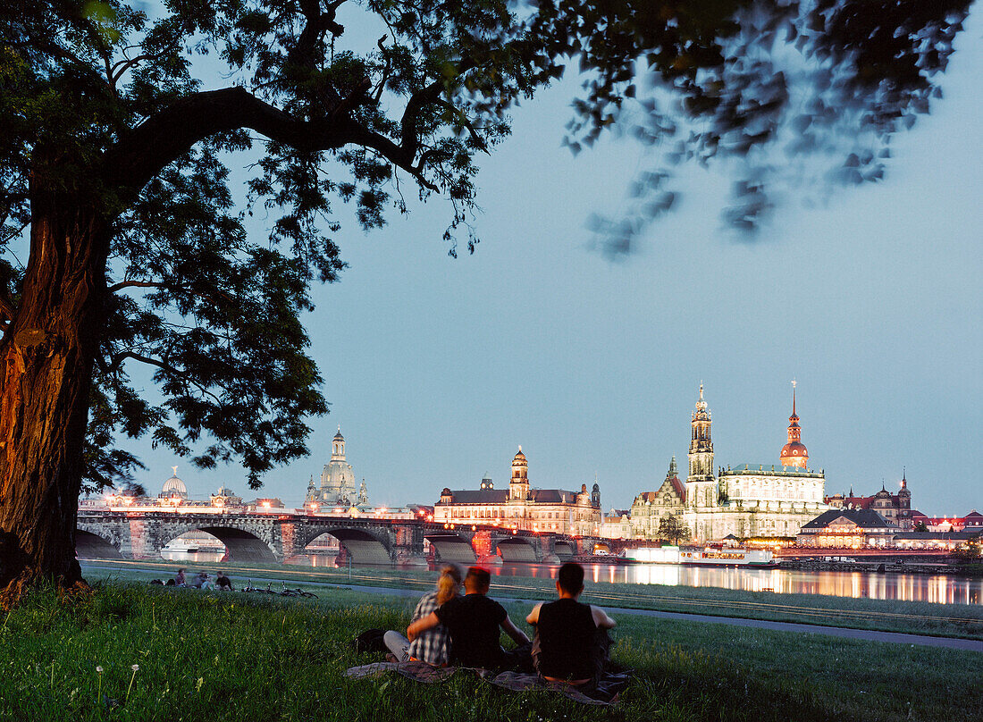 Young people looking at Canaletto-view, Dresden skyline in the evening, Elbe River, Dresden, Saxony, Germany