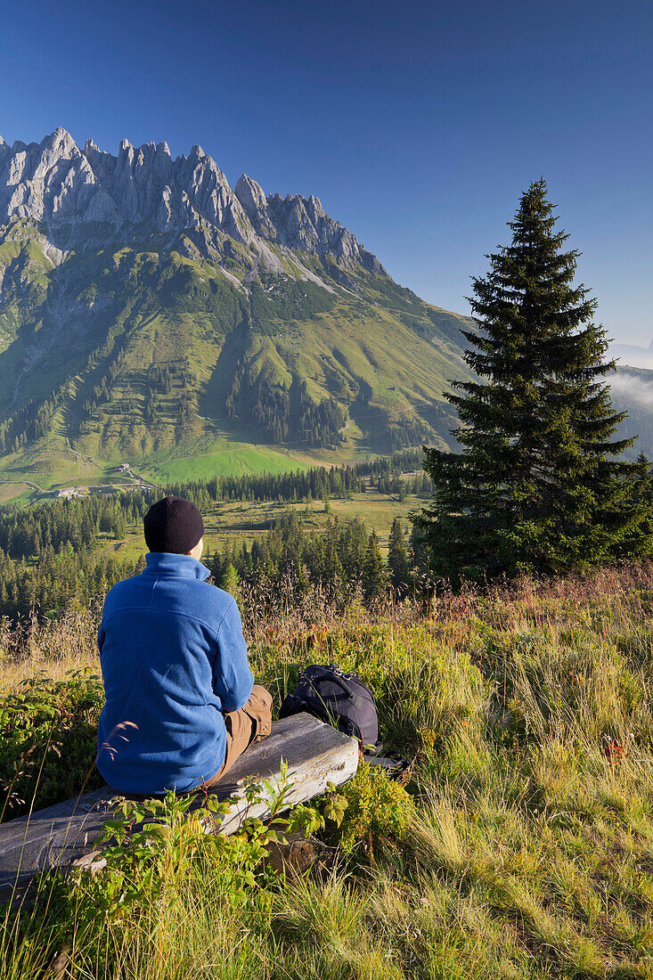 View from Hochkeil onto Mandlwand, hiker having a rest, Hochkoenig, Salzburg, Austria, Europe