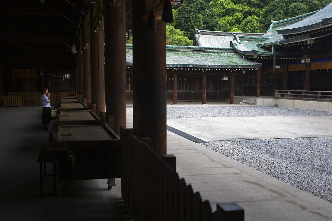 A visitor prays at the Outer Shrine of Meiji-Jingu Shrine, located in the Shibuya district of Tokyo, Japan.