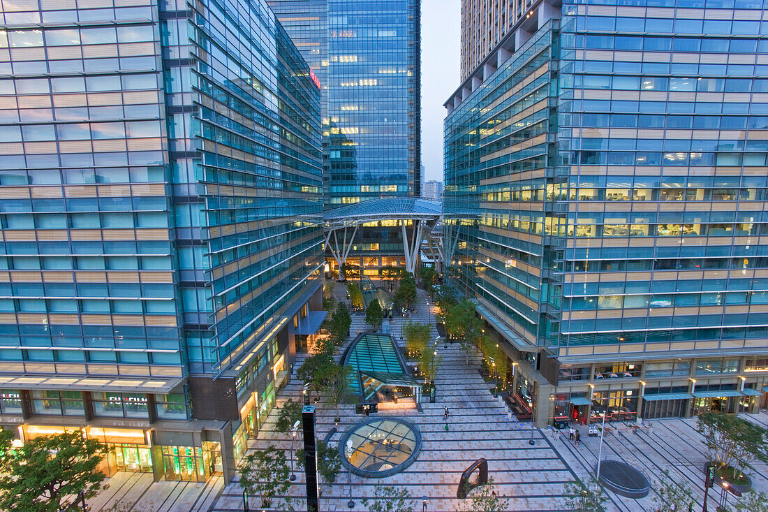 A wide-angle view at twilight shows the main entrance to Midtown Tokyo, one of the city's newest business and commercial complex developments, located in the upscale Roppongi district of Tokyo, Japan.