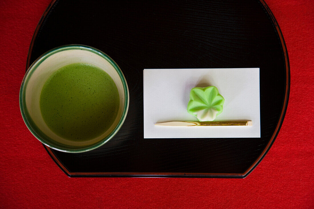 Green tea is served with seasonal okashi Japanese sweets on a black laquer tray at the Fukiage Teahouse inside Rikugien Garden (Six Poem Garden) in the old Komagome District in the northern part of Tokyo, Japan.