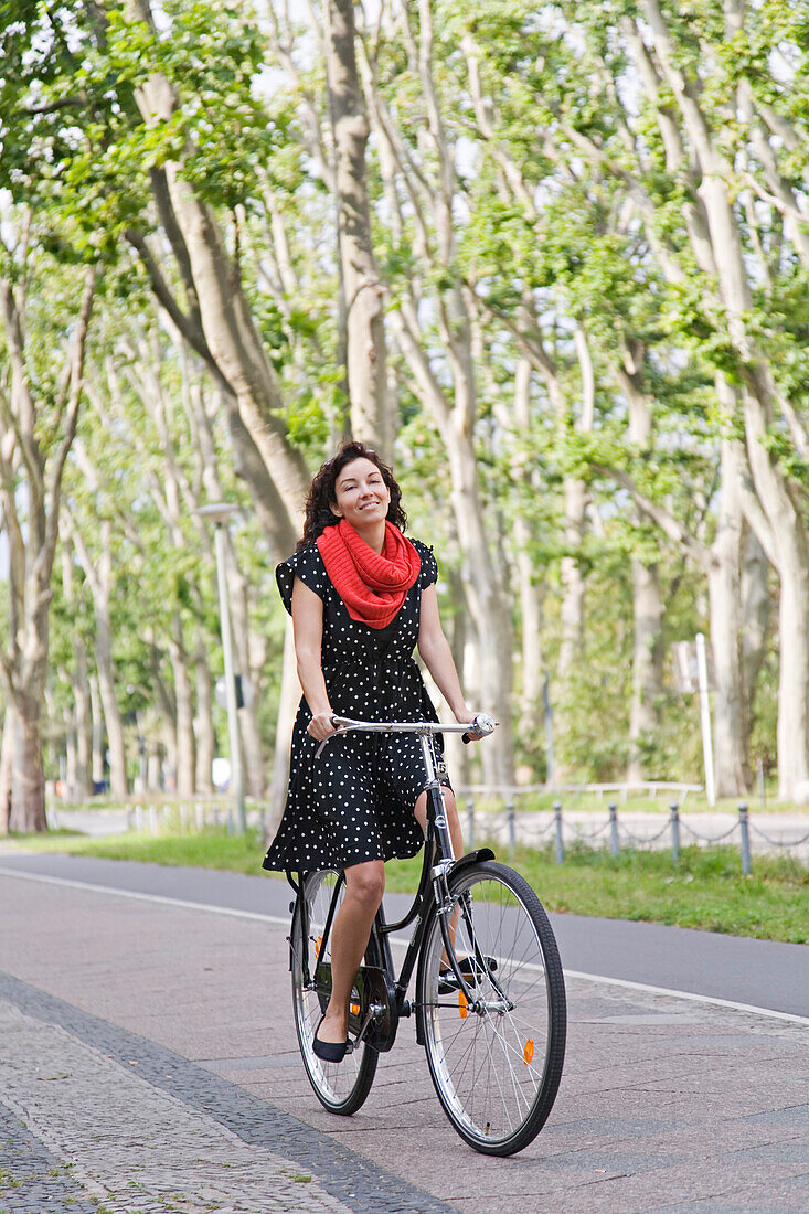 Happy woman riding with the bicycle in the city