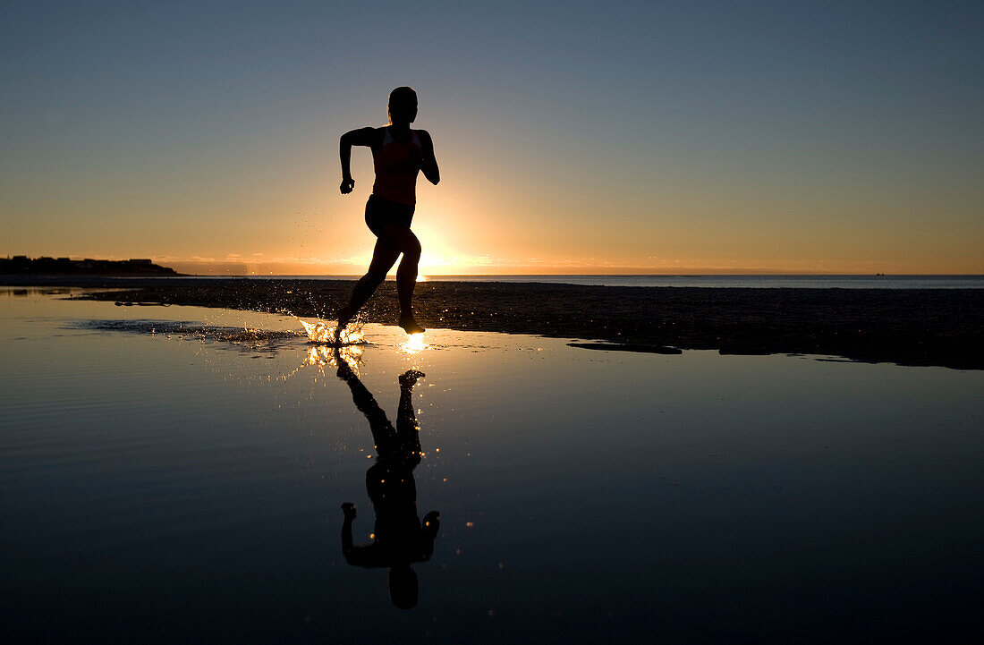 Young Woman Running on Beach at Sunset. Young Woman Running on Beach at Sunset