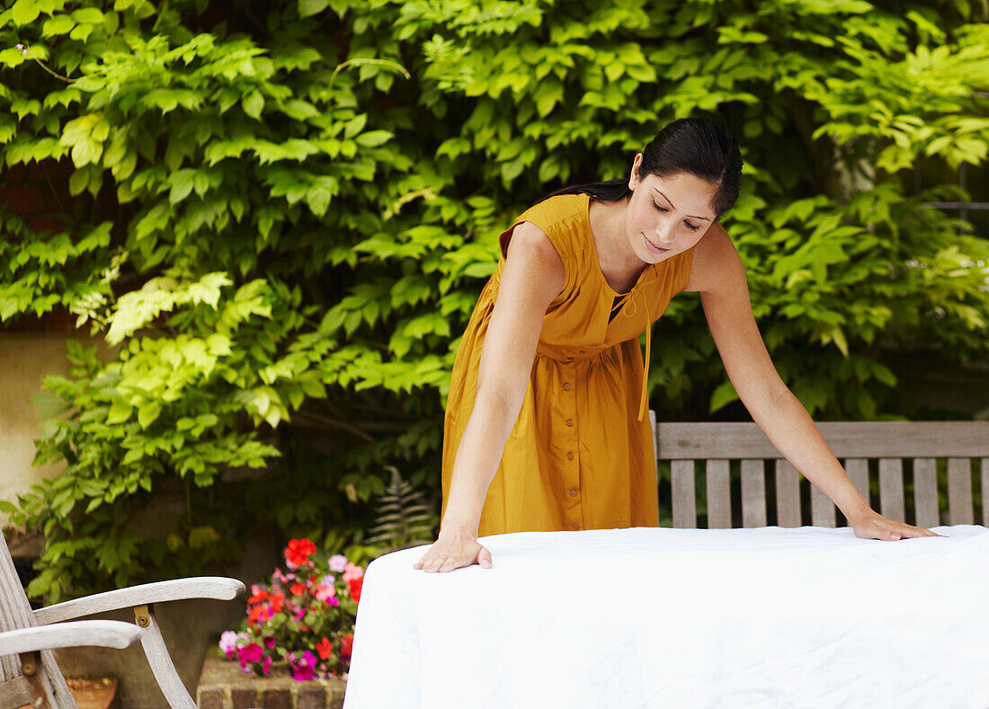 Woman spreading tablecloth outdoors. Woman spreading tablecloth outdoors