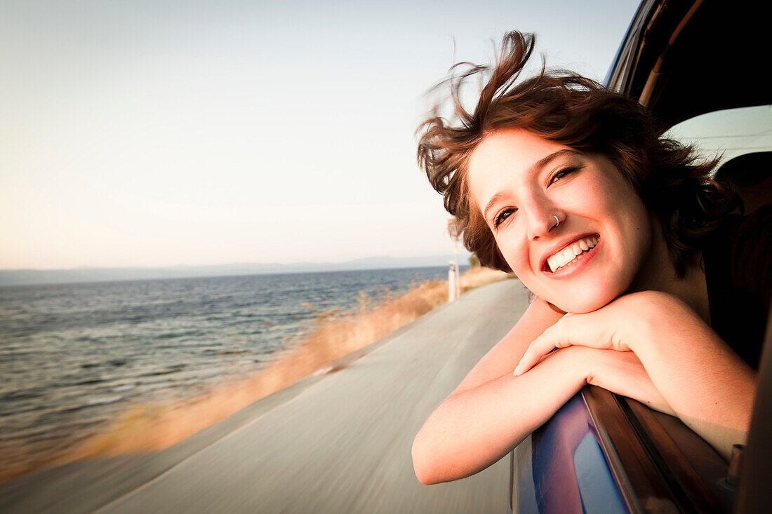 Woman smiling out of car window. Woman smiling out of car window