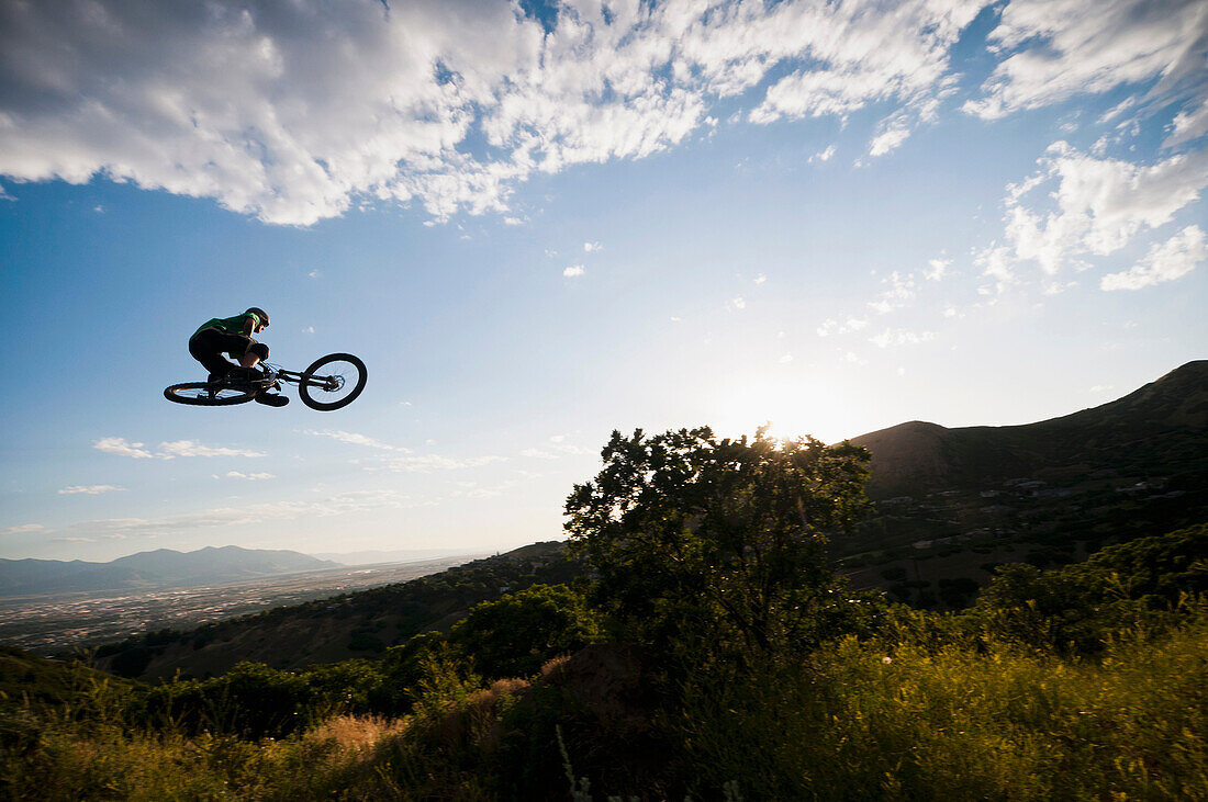 Mountain biker jumping on hillside. I_Street, dirt jumping, BMX