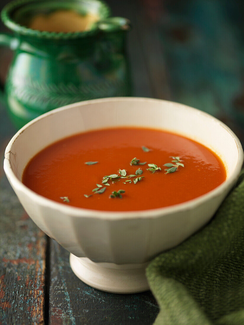 Close up of bowl of tomato soup. Tomatoe soup garnished with fresh thyme