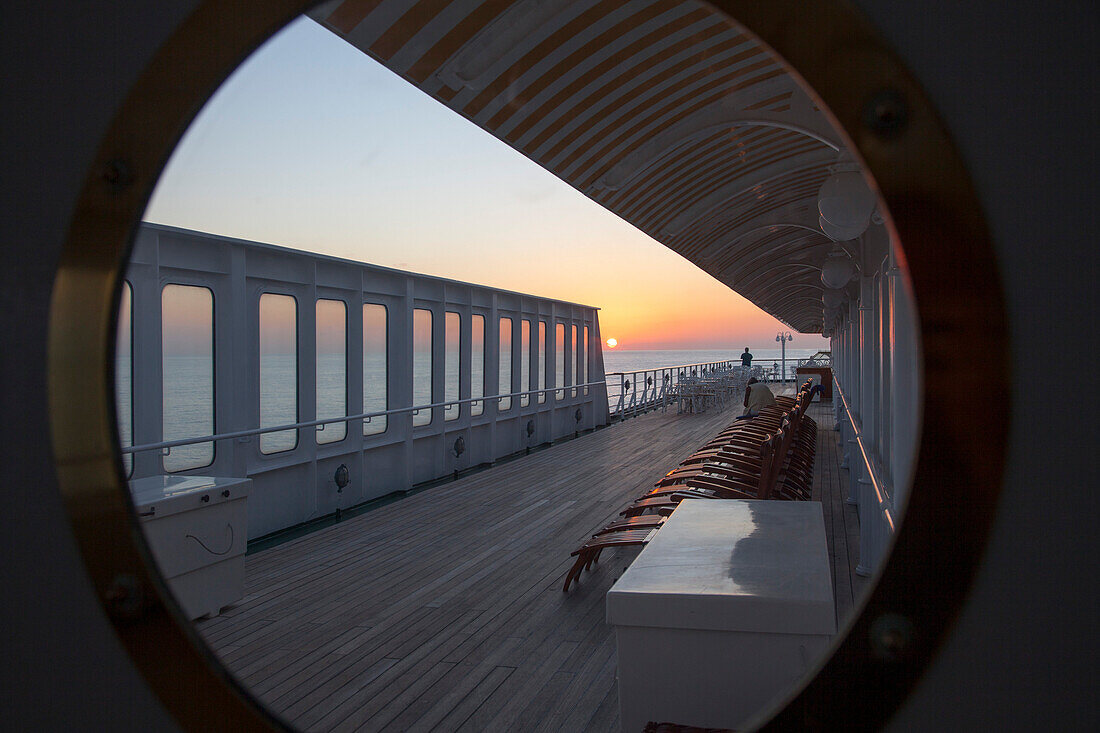 Sunset view through window on deck of cruise ship MS Deutschland (Reederei Peter Deilmann), Caribbean Sea, near Mexico