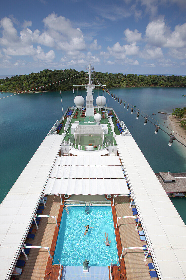 Pool and deck of cruise ship MS Deutschland (Reederei Peter Deilmann) and narrow harbor entrance, Port Antonio, Portland, Jamaica, Caribbean