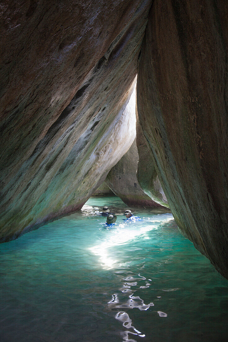 People swimming among giant granite boulders at The Baths, Virgin Gorda, Virgin Gorda, British Virgin Islands, Caribbean
