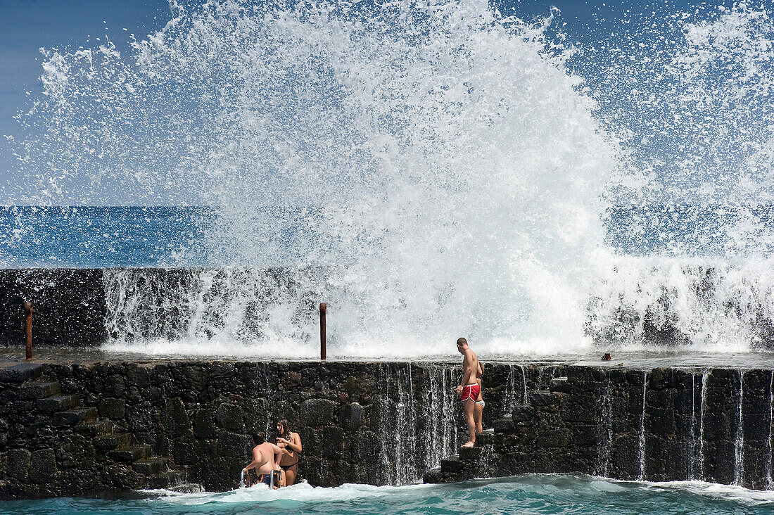Bathers and waves at harbour, Puerto de la Cruz, Tenerife, Canary Islands, Spain, Europe