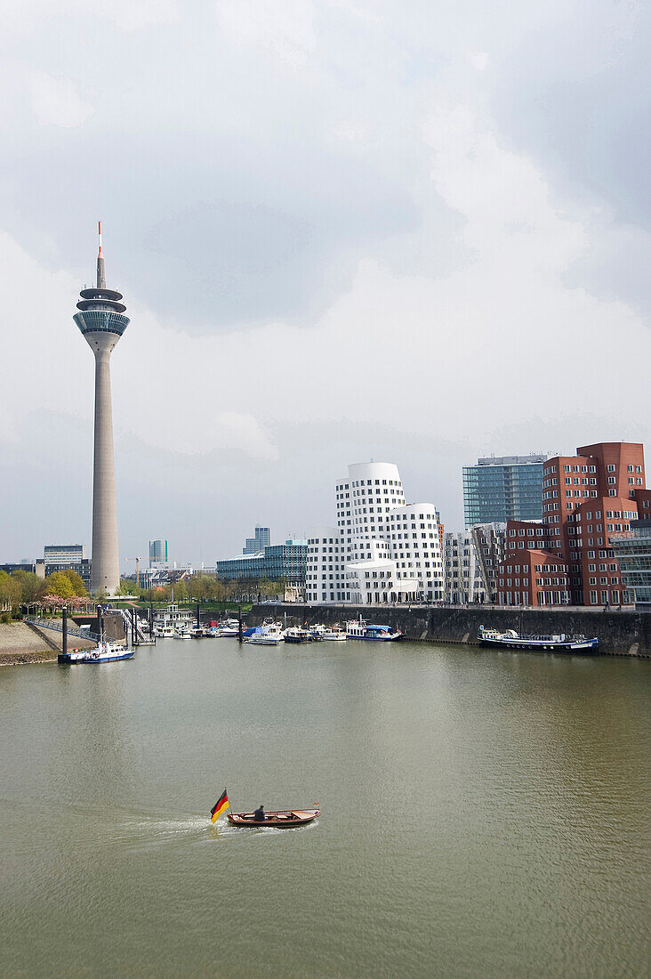 Boot mit Deutschlandfahne im Medienhafen mit Fernsehturm und Häusern des Architekten Frank Gehry, Düsseldorf, Nordrhein-Westfalen, Deutschland, Europa