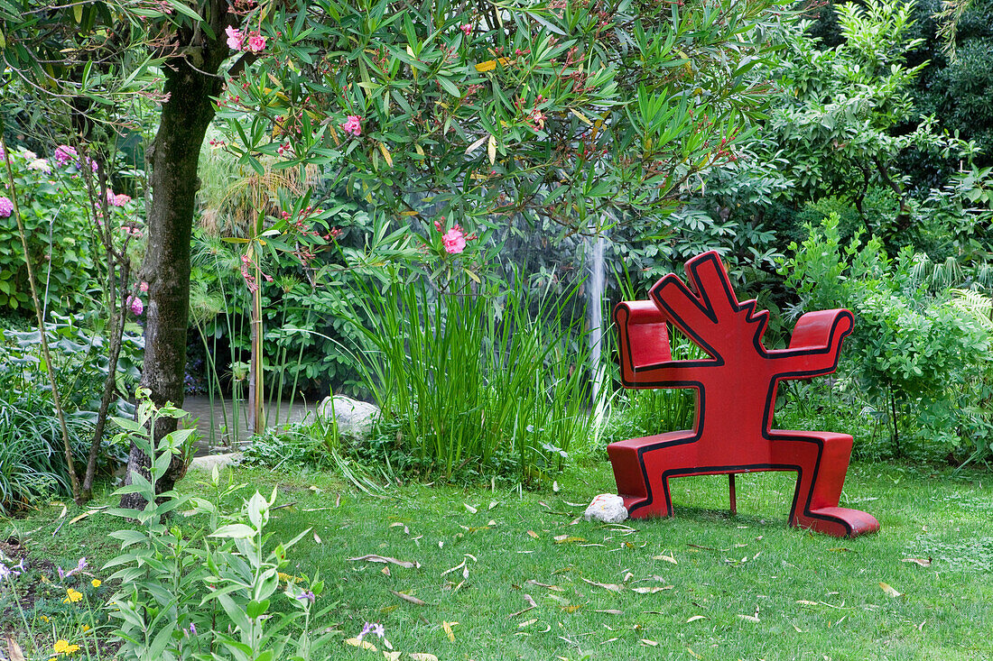 A Keith Haring sculpture with fountain in the background at Andre Hellers' Garden, Giardino Botanico, Gardone Riviera, Lake Garda, Lombardy, Italy, Europe