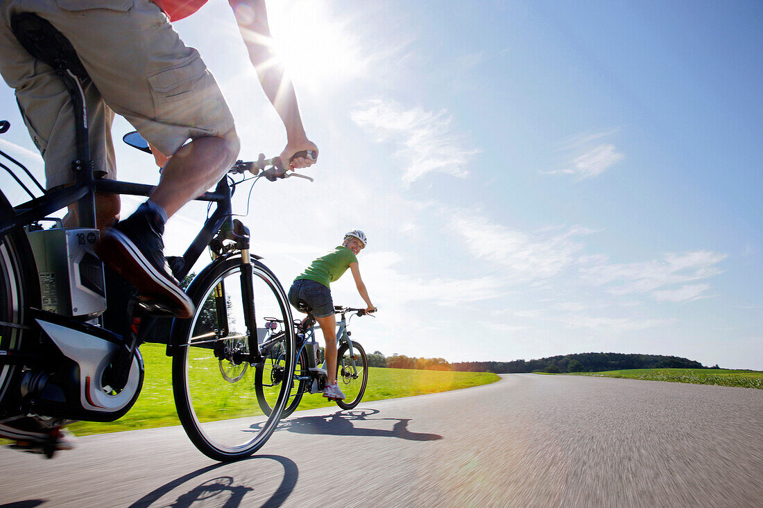 Young woman and young man on an e-bike, Lake Starnberg, Upper Bavaria, Germany