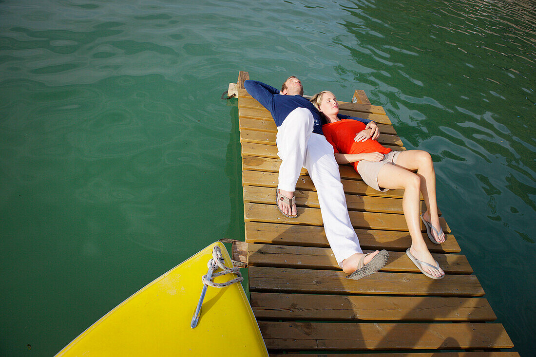 Young couple lying relaxed on a jetty, Woerthsee, Bavaria, Germany, Europe