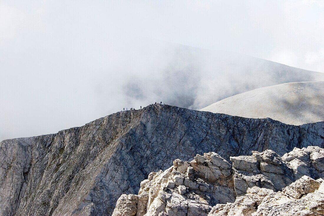 One of Olympus mountain peaks with people on the top of it shoot on a cloudy day, Olympus Mountain, Pieria, Macedonia, Greece