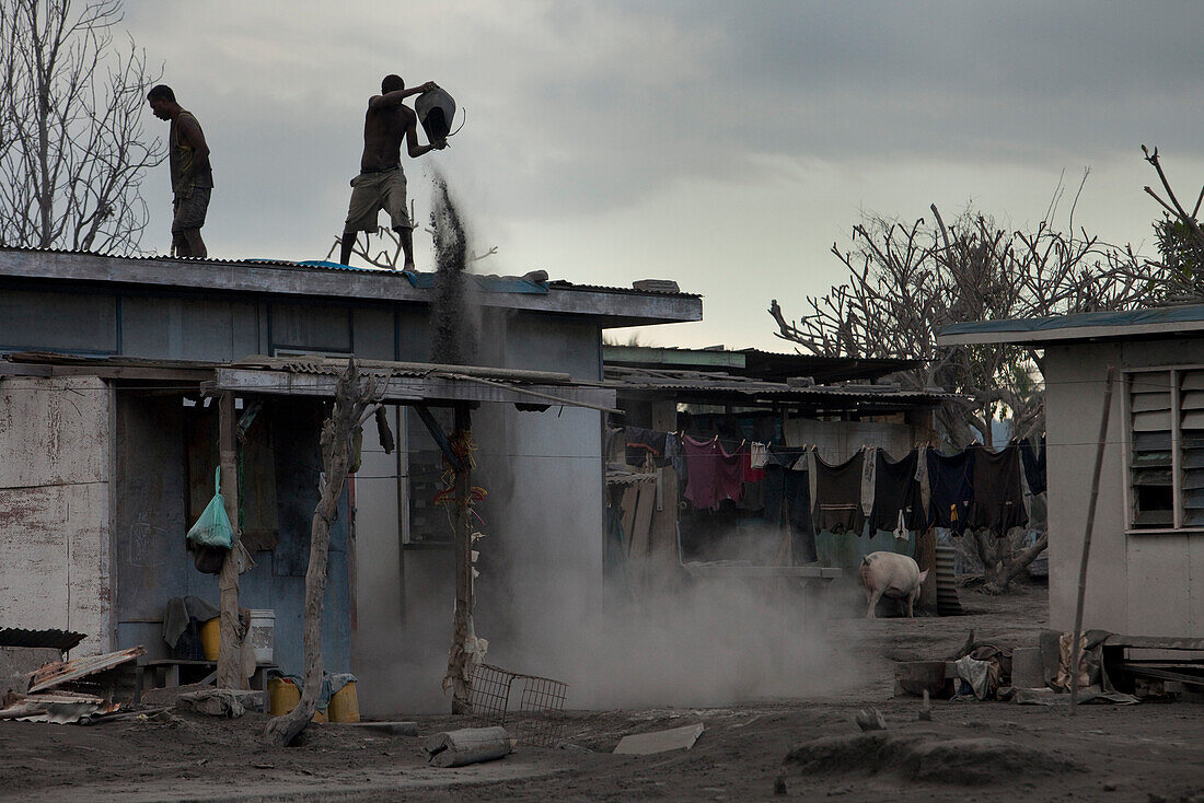 Zwei Männer befreien das Dach eines Hauses vom Vulkanasche, Tavurvur Vulkan, Rabaul, Ost-Neubritannien, Papua Neuguinea, Melanesien, Pazifik