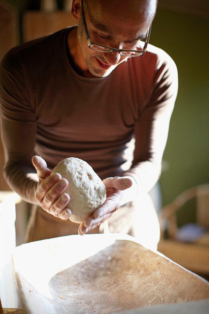 Man kneading bread dough, Klein Thurow, Roggendorf, Mecklenburg-Western Pomerania, Germany