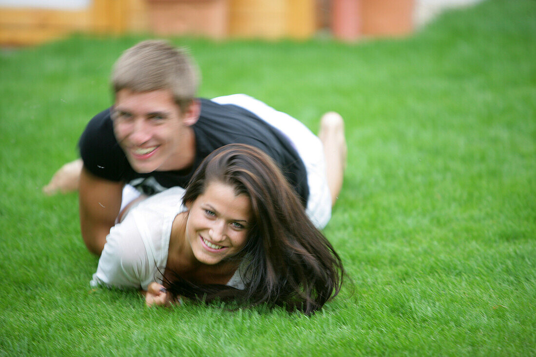 Young couple romping in meadow, Vienna, Austria