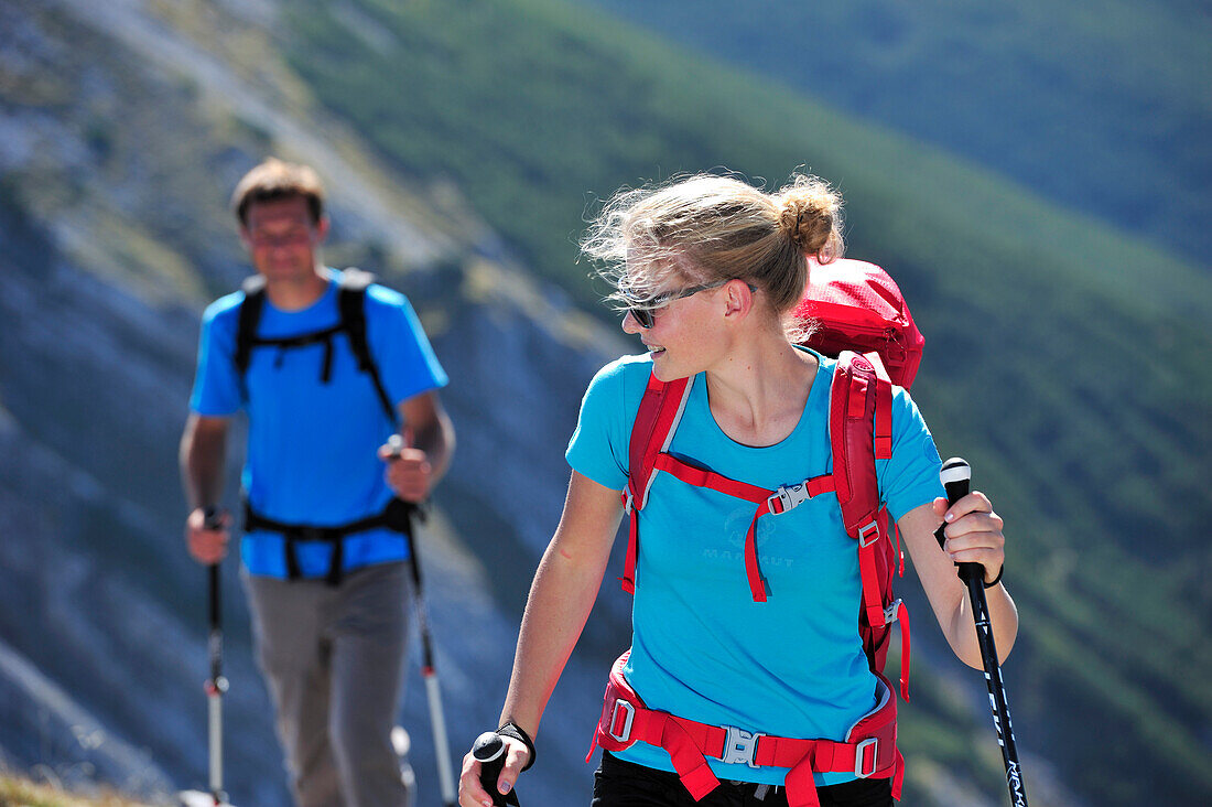 Young woman and young man hiking on ridge, Unnutz, Brandenberg Alps, Tyrol, Austria