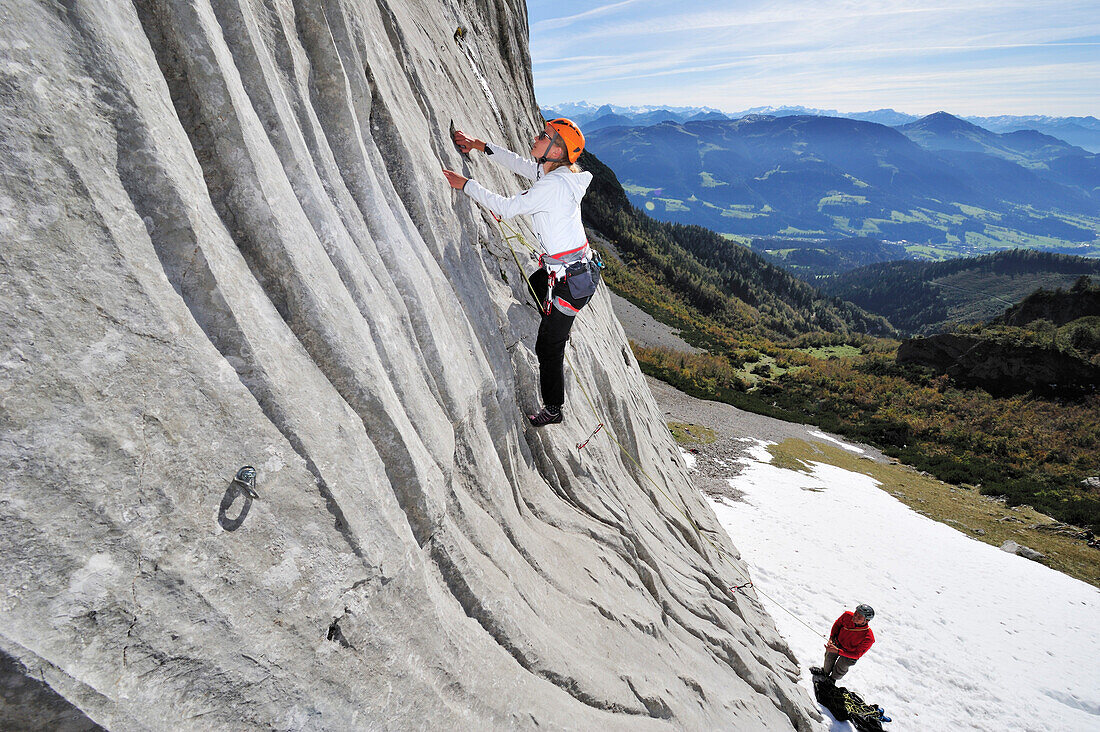 Junge Frau klettert und wird von jungem Mann gesichert, Multerkarwand, Treffauer, Wegscheidalm, Wilder Kaiser, Kaisergebirge, Tirol, Österreich