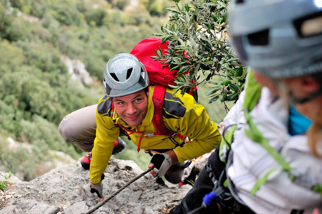 Young woman and young man climbing fixed rope route Rino Pisetta, Lago die Toblino, Sarche, Calavino, Trentino, Trentino-Alto Adige, Suedtirol, Italy