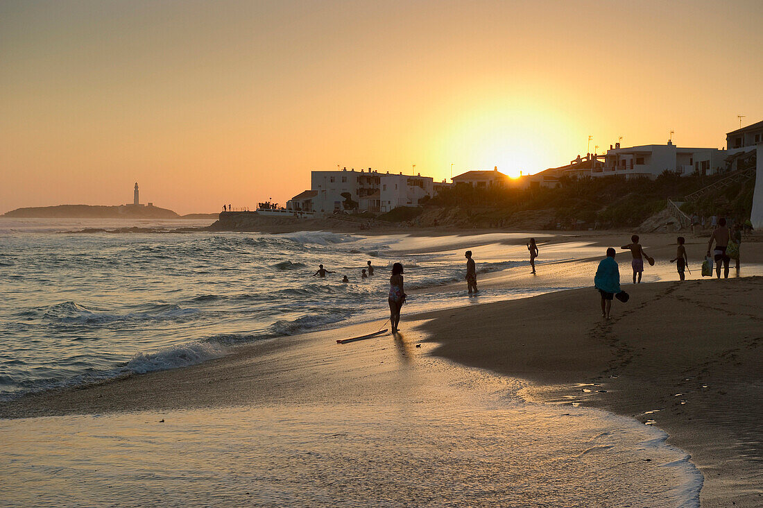 Menschen am Strand bei Sonnenuntergang, im Hintergrund das Cabo de Trafalgar, Los Canos de Meca, Andalusien, Spanien, Europa