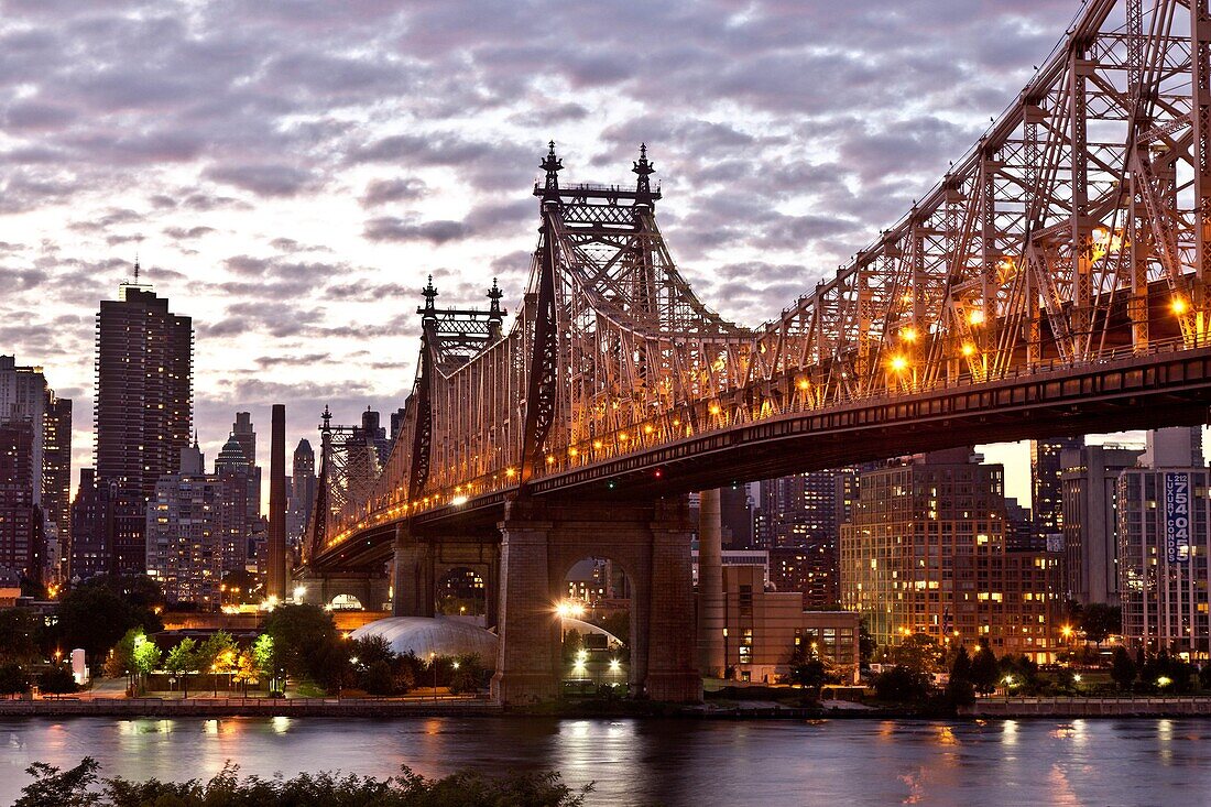 New York - United States, view on Manhattan skyline, East river and the Queensboro bridge, Queens during sunset, stormy sky