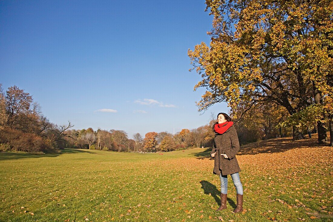Portrait of a brunette woman in park in Autumn