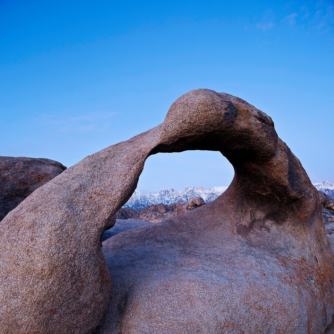 Mobius Arch stone arch in the Alabama Hills with Sierra Nevada mountains in distance, Lone Pine, California