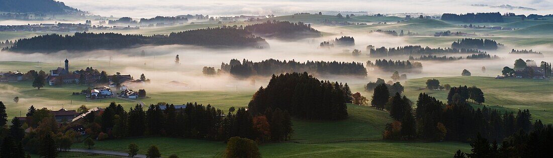 Autumn morning fog clears from rural landscape of Allgaeu region near Eisenberg, Bavaria, Germany