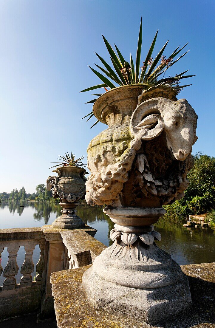 Stone urn sculpture by John Thomas in front of Long Water, Italian Garden, Kensington Gardens, London, UK