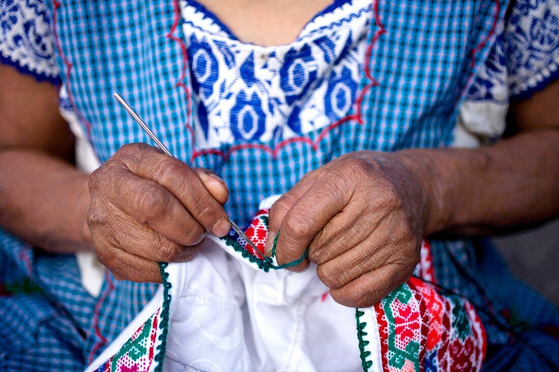 A woman stitches a design on the top of a blouse in Cuetzalan del Progreso, Mexico. Cuetzalan is a small picturesque market town nestled in the hills of Mexico´s central state of Puebla Founded in 1547 by Franciscan friars, this town took its name from th
