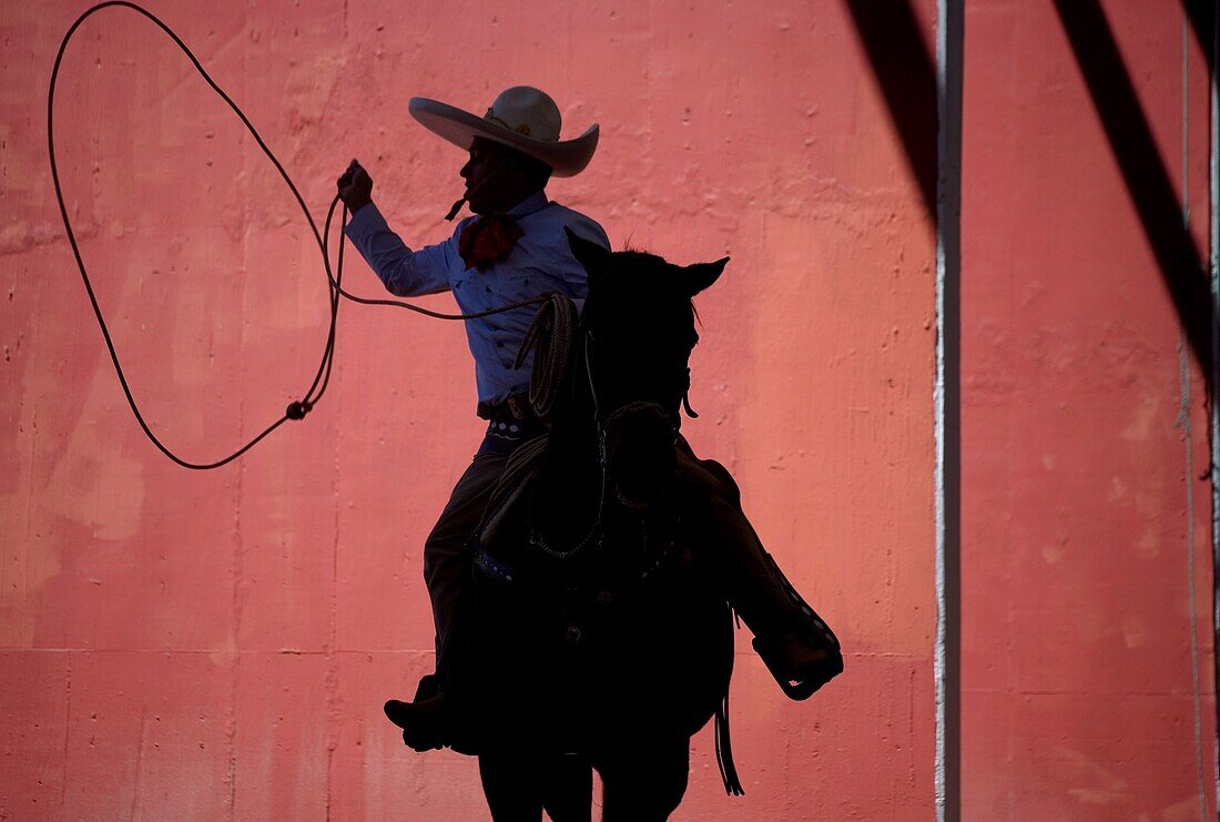 A Mexican charro practices his lasso at the National Charro Championship in Pachuca, Hidalgo State, Mexico. Escaramuzas are similar to US rodeos, where female competitors called ´Amazonas´ wear long skirts, and ride side saddle Male rodeo competitors are