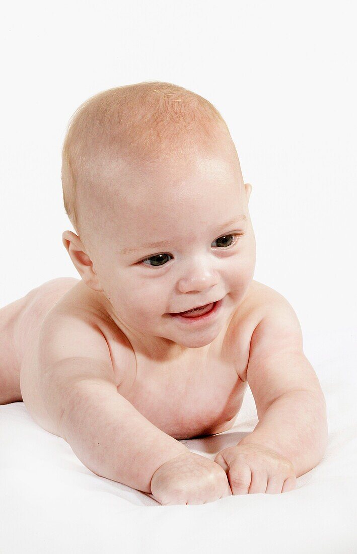 BABY, BOY SMILING AGAINST WHITE BACKGROUND