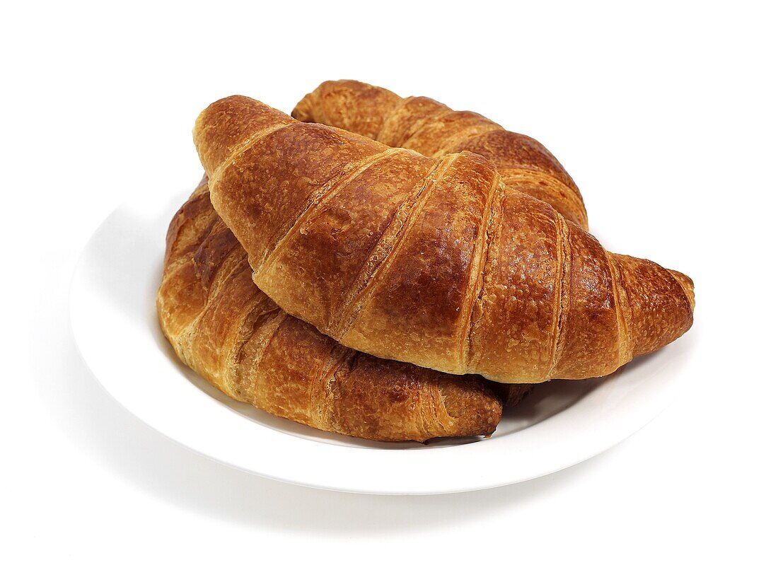 PLATE WITH CROISSANTS AGAINST WHITE BACKGROUND
