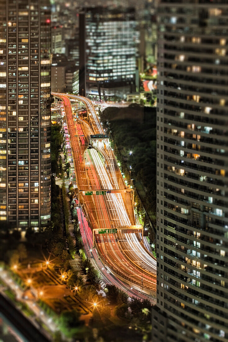 Tokyo Freeway and Skyscrapers at Night. View from above.An elevated roadway with traffic and car lights. Tall buildings. Modern architecture., Tokyo, Japan. Downtown freeway road