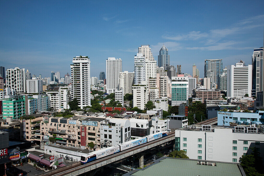 A mass transit train passes through Bangkok downtown business district. Modern architecture. Skyscrapers. Public transport., Bangkok, Thailand. City skyline and mass transit train