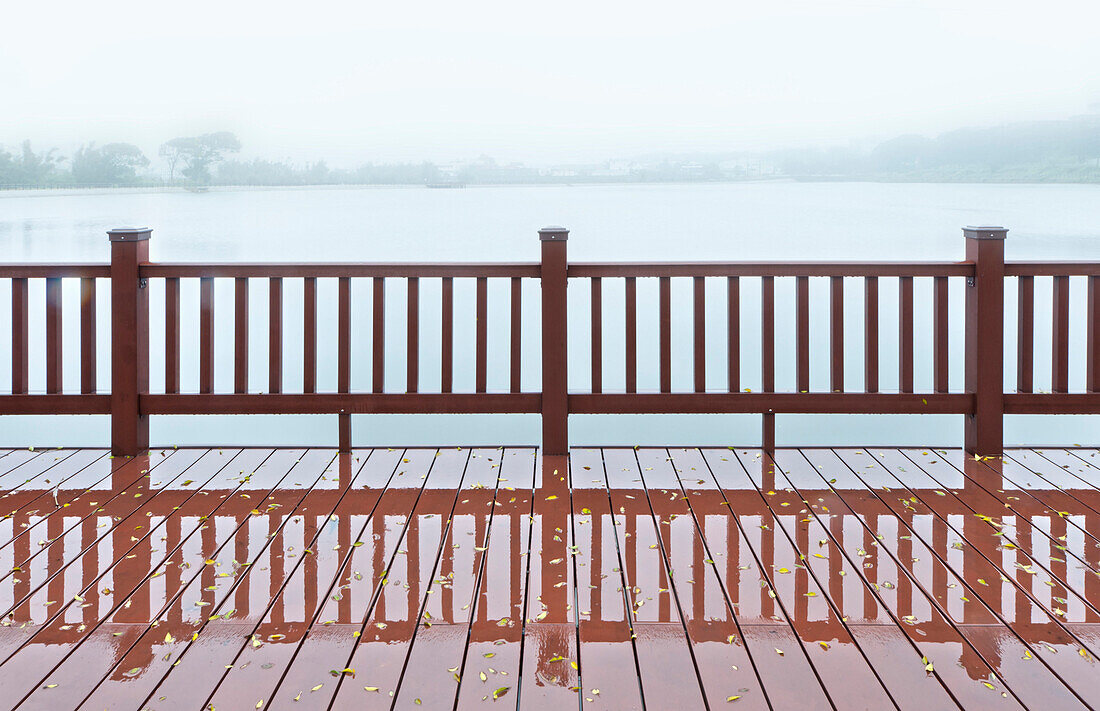 A wooden boardwalk and railings, on the shores of a lake. Mist rising from the water. Dawn or dusk., Lake, Taiwan, Asia.
