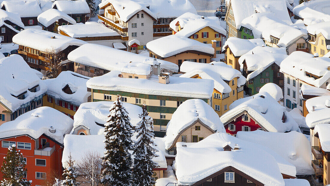 Snowy rooftops in the town of Andermatt, after a heavy winter snowfall. Ski resort and travel destination inthe San Gottard valley of the Oberalp in Switzerland., Andermatt, Switzerland