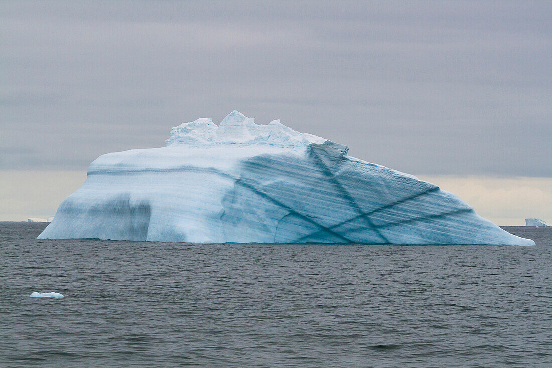 Blue iceberg with Laurie Island, Washington Strait, South Orkneys, Southern Ocean, Antarctica