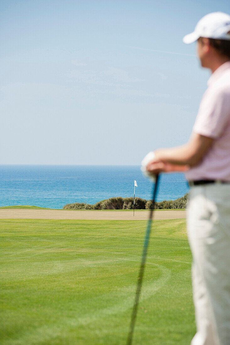 Golf player facing green and pin at golf course, Costa Navarino, Peloponnese, Greece, Europe