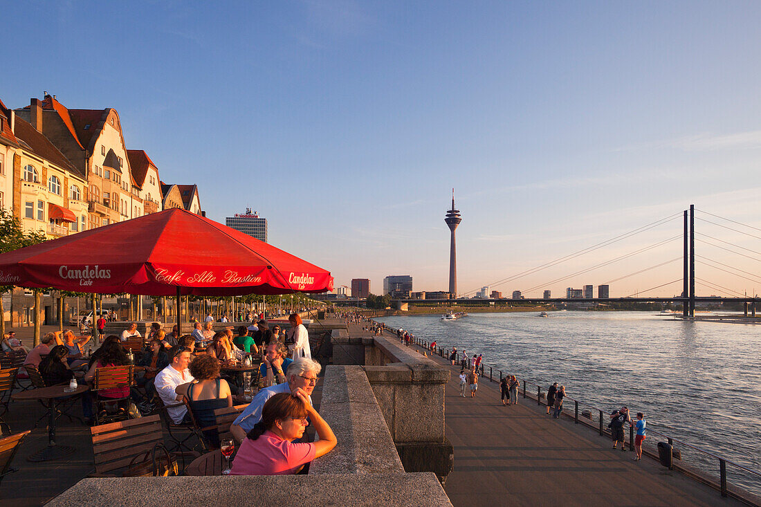 Terrace of a restaurant at the Rhine river promenade in the evening light, Duesseldorf, North Rhine-Westphalia, Germany, Europe