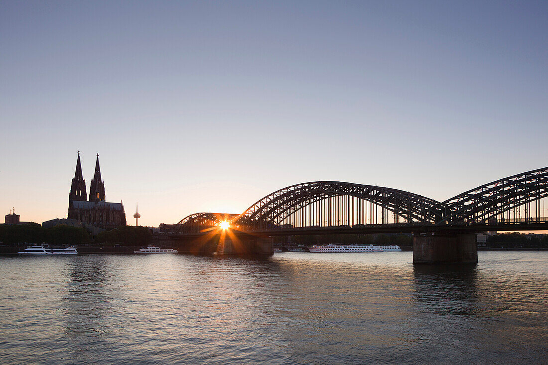 View over the Rhine river onto the cathedral and Hohenzollern bridge at sunset, Cologne, North Rhine-Westphalia, Germany, Europe