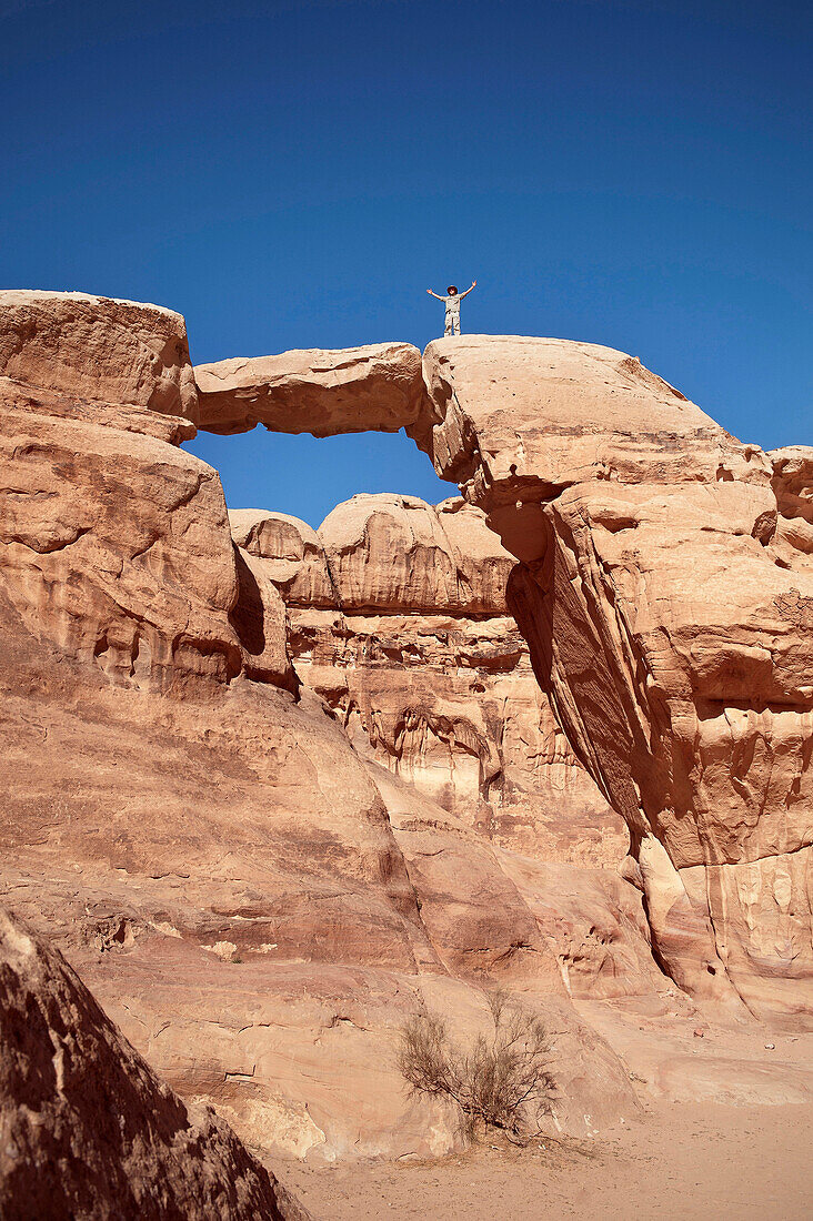 Reisender steht auf Felsbrücke im Wadi Rum, Jordanien, Naher Osten, Asien