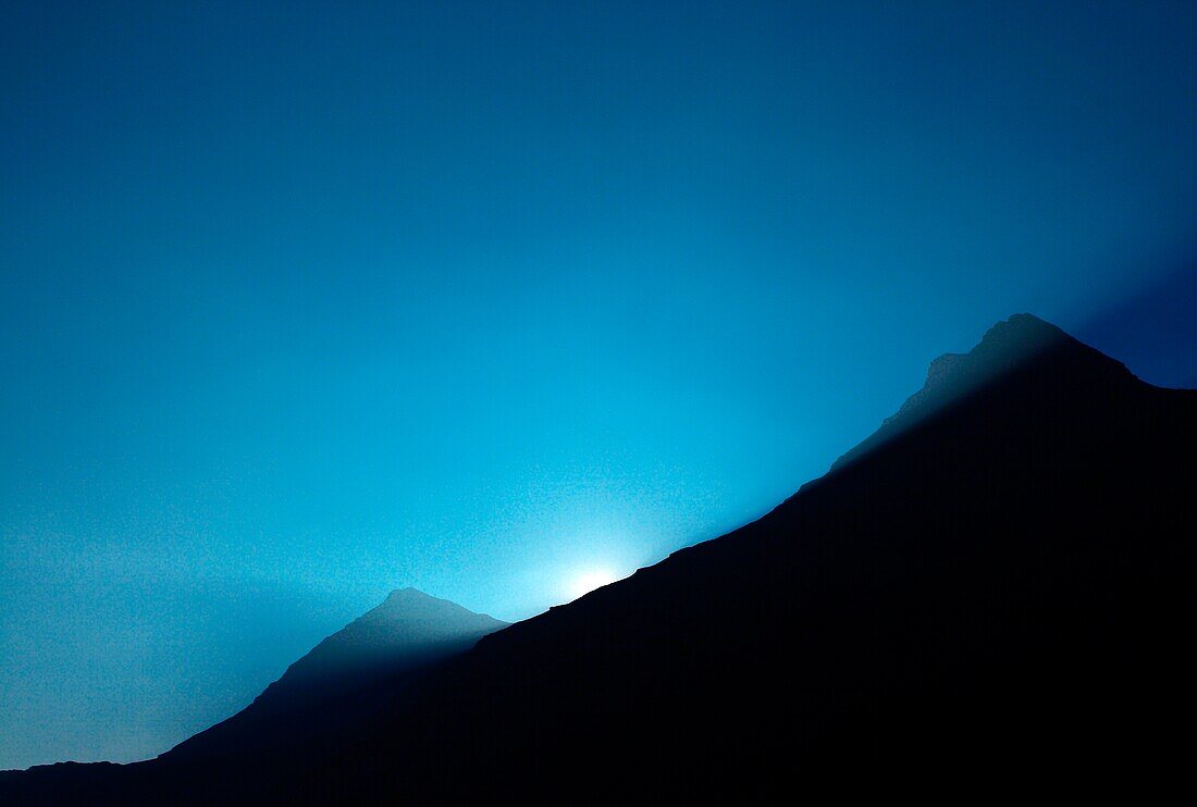 France, mountain Alpes silhouette at sunrise with rays of the sun, flush with the tops