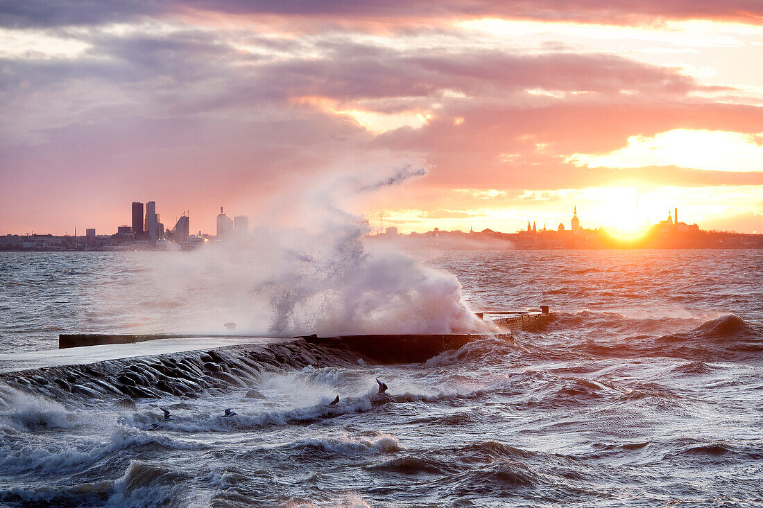 A weather storm, creating  waves crashing over the Pier and coastline in Tallinn, Estonia. The Baltic Sea. Sunrise., Tallinn coastline and stormy seas